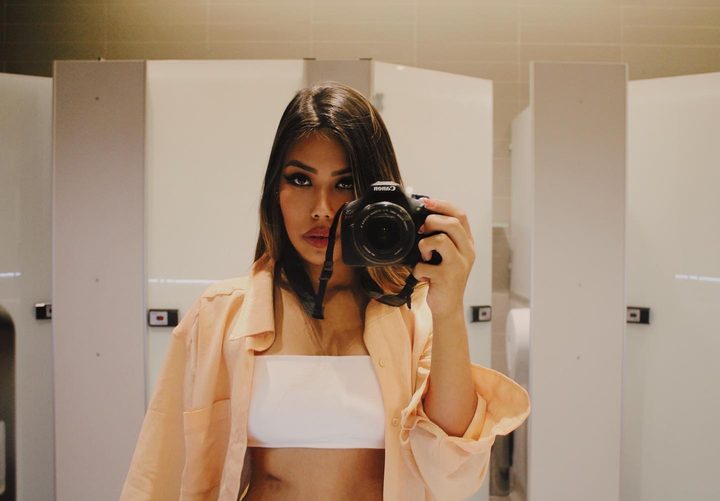 Yasmim fotografando no espelho com uma câmera Canon